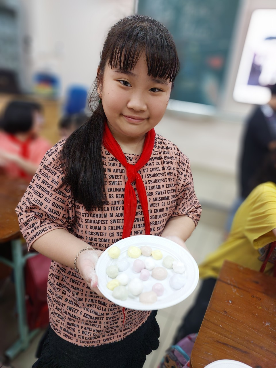 A child holding a plate of food

Description automatically generated