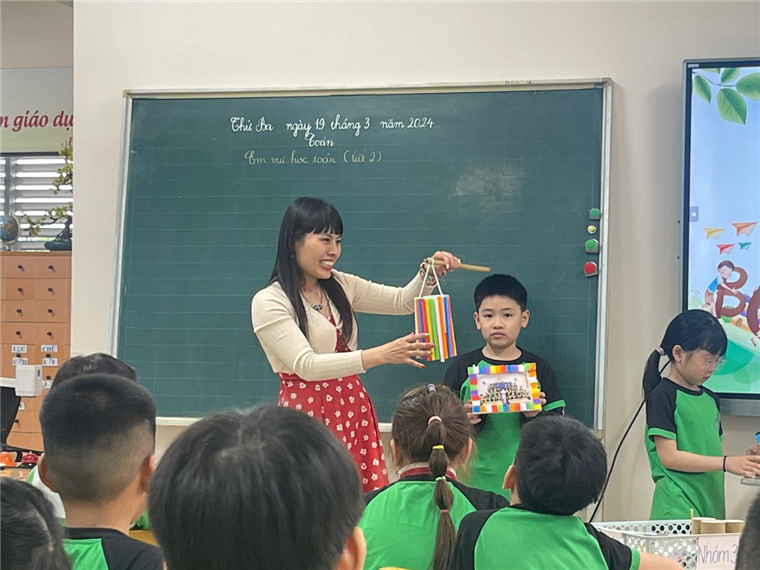 A person holding a bag with a child in front of a chalkboard

Description automatically generated